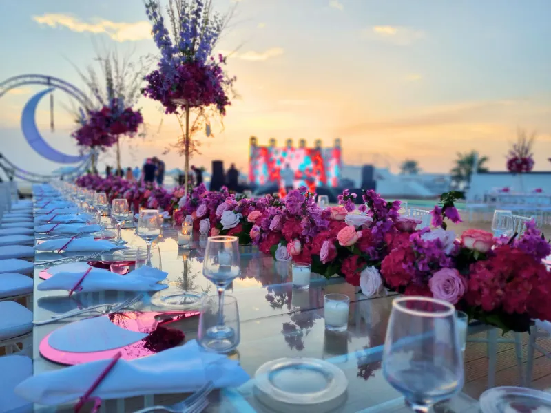 Tavolata con fiori fucsia al tramonto per una festa